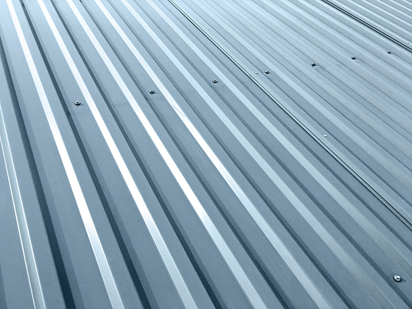 Corrugated gray metal sheets with rivets on roof of an industrial building